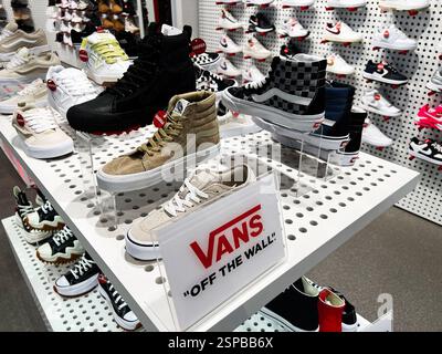 Leopoli, Ucraina - 13 febbraio 2025: Le calzature colorate di Vans sono esposte in modo ordinato su scaffali in un moderno ambiente di negozi di scarpe. Foto Stock