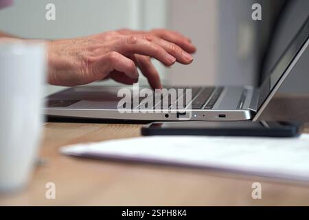 Ispirazione creativa di uno scrittore: Una donna anziana scrive un testo su un portatile Foto Stock