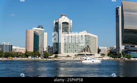 Dubai, Emirati Arabi Uniti - 13 novembre 2024: Lo Sheraton Dubai Creek Hotel sorge lungo il Dubai Creek nella zona di Riggat al Buteen, circondato da acqua, barche e dalla città Foto Stock