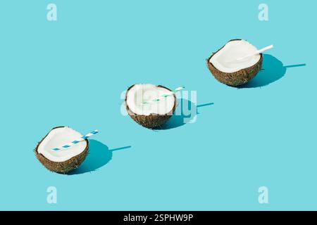 Disposizione della frutta a base di noci di cocco su sfondo azzurro pastello. Concetto di spiaggia tropicale minimale. Natura composizione estiva. Un'idea di festa estiva alla moda Foto Stock