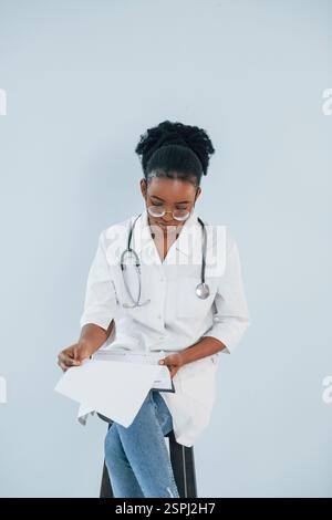 La giovane donna afroamericana è su sfondo bianco. Foto Stock