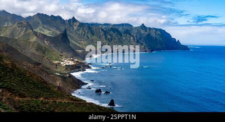 Una splendida vista costiera caratterizzata da scogliere aspre, vegetazione lussureggiante e un oceano sereno. Il paesaggio mostra montagne spettacolari che incontrano il mare sotto a. Foto Stock