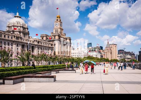Pedoni che passeggiano lungo il Bund, una famosa passeggiata sul lungomare costeggiata da edifici di epoca coloniale, Shanghai, Cina. Foto Stock