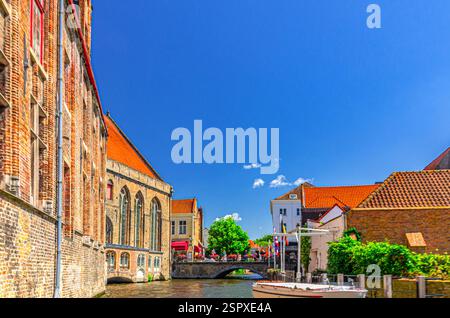 Il canale d'acqua di Bakkersrei, il Ponte di Maria e il Museo medievale edificio Sint-Janshospitaal con piante e alberi verdi nel centro storico di Bruges, Bruges, c Foto Stock