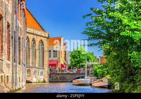 Il canale d'acqua di Bakkersrei, il ponte di Mariabrug e l'edificio del Museo Sint-Janshospitaal con alberi verdi nel quartiere storico di Bruges, la città storica di Bruges Foto Stock