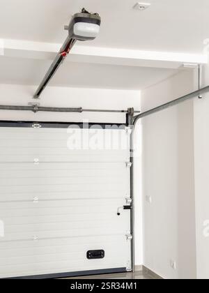 Moderno meccanismo della porta del garage con meccanismo di apertura elettrico e robusti binari in metallo. Foto Stock