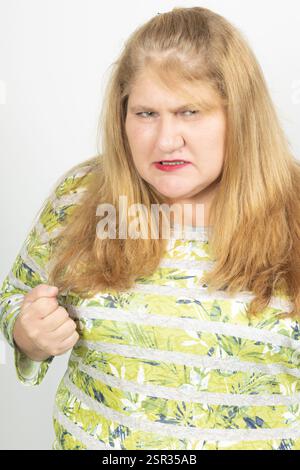 Ritratto ravvicinato di una donna adulta con capelli biondi e occhi verdi, che mostra rabbia e determinazione. Foto Stock