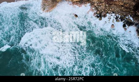 Vista aerea delle onde oceaniche che si schiantano sulle rocce a Nazare, Portogallo Foto Stock