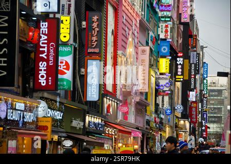 Myeongdong Street, Seoul, Corea del Sud. Strada trafficata con vari negozi e cartelli in coreano e inglese. Popolare destinazione per lo shopping e il divertimento. Foto Stock