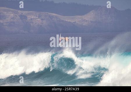 Surfista spazza via un'onda su Maui. Foto Stock