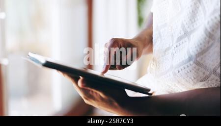 Mani, scorrimento e tablet con persona a casa per il download, i social media o l'abbonamento. App, dati biometrici e dito per l'accesso all'account personale Foto Stock