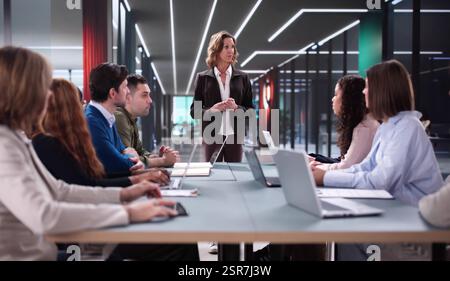 Il manager conduce una riunione aziendale diversificata. Formazione aziendale in corso. Foto Stock