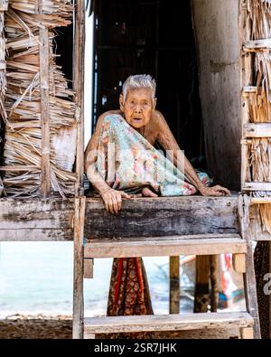 Phangnga, Thailandia, 21 gennaio 2025, un anziano abitante di un villaggio si trova in una casa di legno sull'isola di Surin, dando un'occhiata alla vita quotidiana e alla cultura della comunità locale Foto Stock