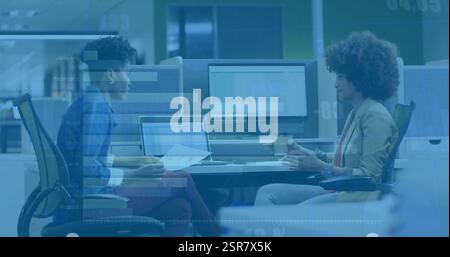 Immagine di diagrammi ed elaborazione dei dati su colleghi birazziali che parlano in ufficio Foto Stock