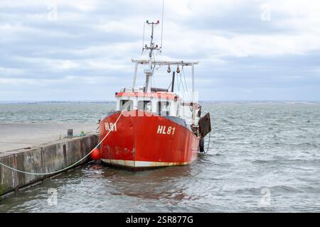 Red and White Cockle Boat ormeggiato e galleggiante sul lungomare di Leigh-on-Sea, Essex Foto Stock
