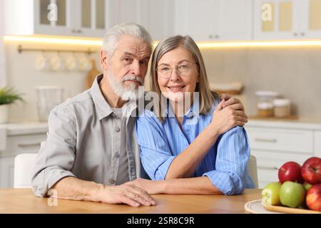 Ritratto di una coppia di anziani carini a tavola in cucina Foto Stock