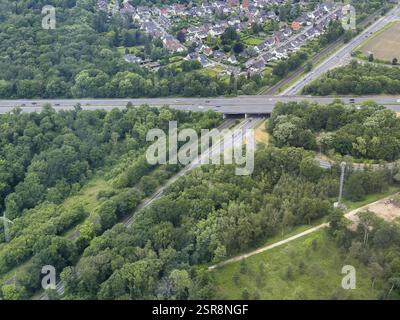 Vista aerea dell'autostrada a sei corsie con ponte, sei corsie stradali che attraversano l'area boscosa, al limite superiore dell'insediamento pittorico con un'area separata Foto Stock