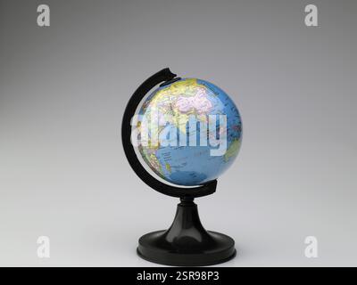 Globo con supporto nero su sfondo grigio Foto Stock