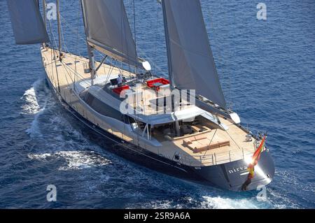 Veduta aerea di Stern dello Yacht a vela di lusso Nirvana che scivola attraverso le calme acque dell'Oceano Blu Foto Stock