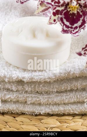 Elementi di Spa con asciugamani bianchi, sapone naturale e orchidee Foto Stock