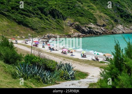 Ombrelloni colorati lungo il lato nord-ovest della spiaggia di Prainha con vegetazione lussureggiante sotto le calde giornate estive di sole pomeridiane. Foto Stock