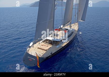 Veduta aerea di Stern dello Yacht a vela di lusso Nirvana che scivola attraverso le calme acque dell'Oceano Blu Foto Stock