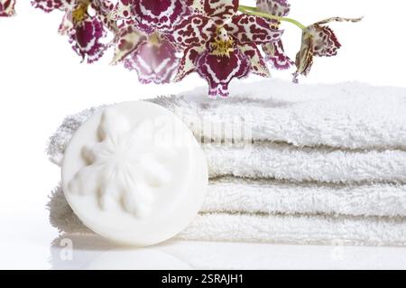 Elementi di Spa con asciugamani bianchi, sapone naturale e orchidee Foto Stock