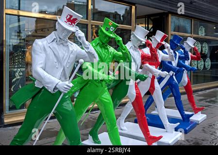 Johnnie Walker Whisky statue di striding man in colori Six Nations rugby fuori dall'esperienza Johnnie Walker in Princes Street, Edimburgo. Foto Stock
