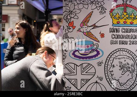 Le persone colorano le opere d'arte di King Charles Coronation. 6 maggio 2023. Foto Stock