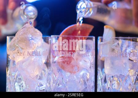 Il barista versa il gin in un bicchiere da cocktail con ghiaccio e fetta di pompelmo in un bar. Probabilmente un cocktail Whitley Neill Gin, in un bar in un establ londinese Foto Stock