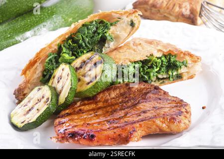 Bistecche alla griglia con sacchetto di pasta sfoglia e zucchine Foto Stock