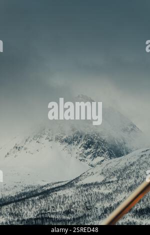 Montagna innevata coperta di nuvole in inverno, le Alpi Lyngen, Norvegia settentrionale Foto Stock