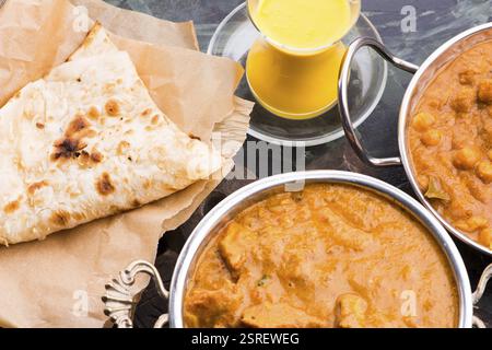 Selezione di curry indiani su piatti in acciaio inossidabile Foto Stock