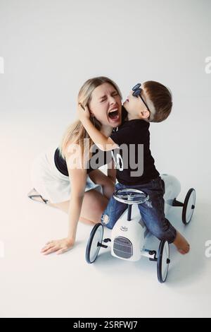 Una madre giocosa e amorevole e suo figlio condividono gioiosamente risate e felicità in un momento delizioso insieme Foto Stock