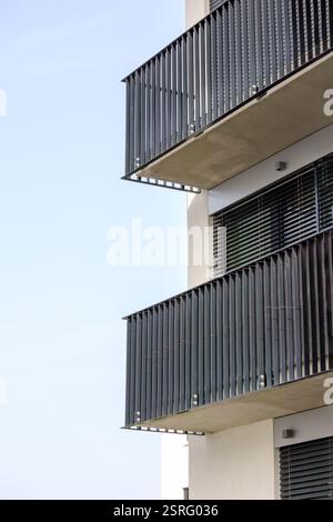 un frammento di un edificio a piu' piani con due balconi che si stagliano su uno sfondo blu. Foto Stock