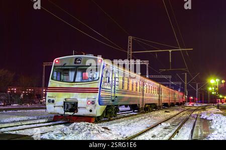Commuter train on a winter night at Kovel station in Volyn Oblast of Ukraine Foto Stock