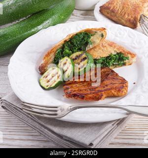 Bistecche alla griglia con sacchetto di pasta sfoglia e zucchine Foto Stock