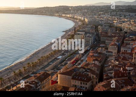 Vista aerea della English Promenade, Nizza, al tramonto, che unisce tetti vivaci e una tranquilla costa mediterranea in una splendida scena costiera. Foto Stock