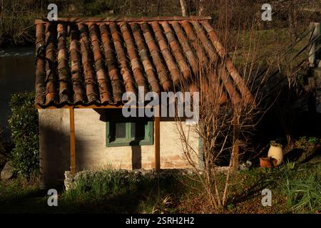 Tranquillo scenario invernale con una piccola casa alla luce del sole mattutino a Mas D'Azil, Ariege, Francia. Foto Stock