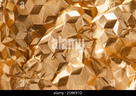 Vista ravvicinata di una struttura tridimensionale metallica dorata con luce e ombra. Foto Stock