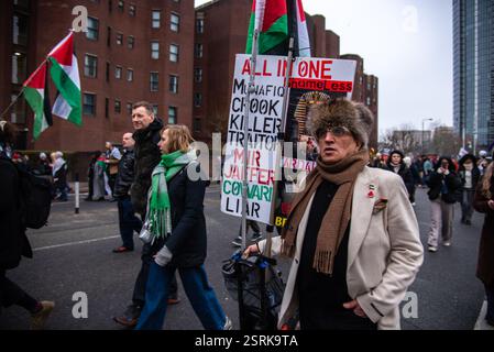 Londra, Regno Unito. 15 febbraio 2025. Un manifestante marcia con un grande cartello e bandiera palestinese durante la marcia Nazionale per la Palestina protesta. Mentre i palestinesi continuano ad affrontare il genocidio di Israele, il colonialismo colono, l'occupazione militare e l'apartheid, a Londra è stata organizzata una campagna di solidarietà con la loro lotta per la libertà, che chiede la libertà della Palestina, no alla pulizia etnica e chiede di smettere di armare Israele. Credito: SOPA Images Limited/Alamy Live News Foto Stock