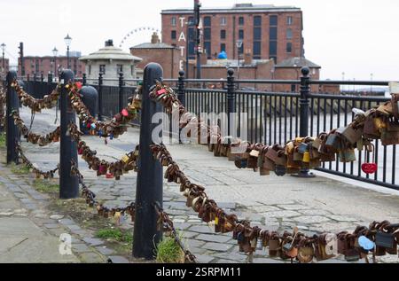 Centinaia di lucchetti d'amore sono attaccate alla recinzione a catena che costeggia il lungomare intorno alla zona di Mann Island a Liverpool. Foto Stock