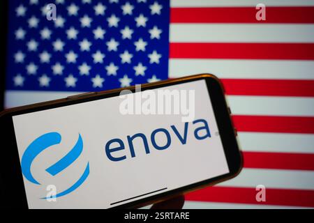 Roosendaal, Paesi Bassi - 16 febbraio 2025: Un telefono cellulare che mostra il logo di Enova Innovations, con la bandiera statunitense sullo sfondo. Foto Stock