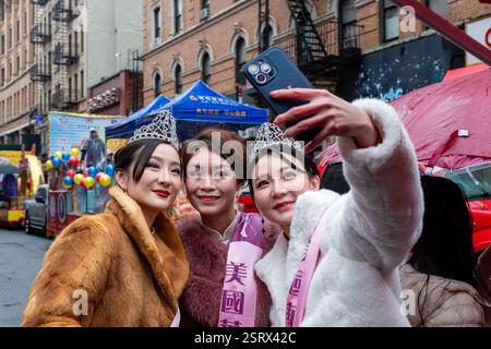 New York, New York, Stati Uniti. 16 febbraio 2025. I partecipanti alla parata del capodanno lunare di Chinatown hanno sfruttato al meglio una giornata di pioggia preparandosi per l'inizio della parata. I vincitori del concorso di bellezza scattano selfie. Crediti: Ed Lefkowicz/Alamy Live News Foto Stock