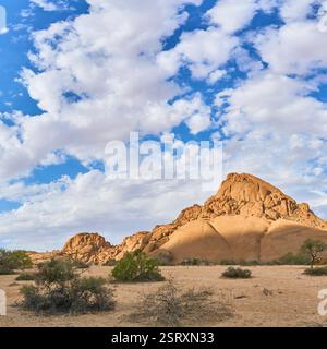 Piccola montagna di Spizkoppe sotto nuvole bianche che coprono il cielo blu, Spitzkoppe, Namibia, Africa Foto Stock
