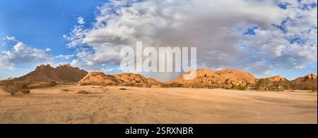 La piccola montagna di Spizkoppe e alcune rocce con la tenda della pioggia, una doccia con un arcobaleno, Spitzkoppe, Namibia, Africa Foto Stock