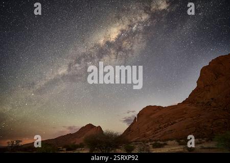 Il nucleo della galassia della via Lattea e molte stelle sopra il Pan di zucchero e le montagne di Spiztkoppe, Namibia, Africa. Foto Stock
