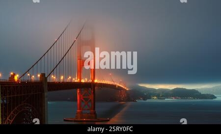 Il Golden Gate Bridge illuminato alle luci del tramonto a San Francisco, California Foto Stock