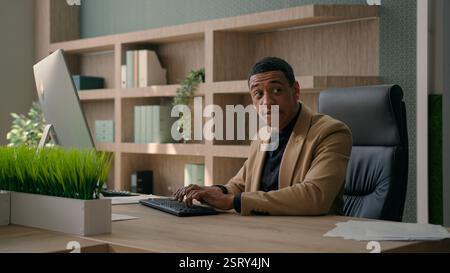 Uomo afro-americano che lavora con documenti aziendali ricerca vendite professionale datore di lavoro responsabile ufficio CEO aziendale Foto Stock