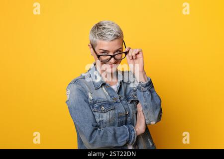 Ti sto guardando. Ritratto di giocosa Donna matura in Eyewear elegante Foto Stock